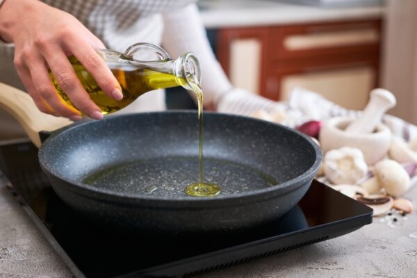 donna che frigge olio di oliva in una padella